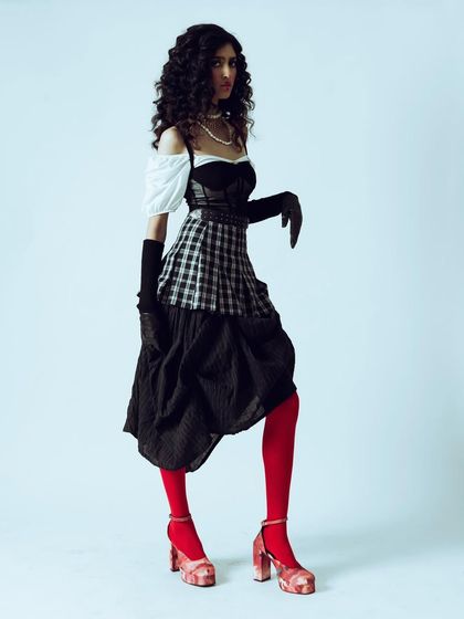 A full-body pose that emphasizes the unique silhouette and styling of the vintage-inspired outfit.