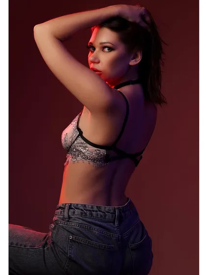 A side-profile shot from the red-lit series, highlighting the model's silhouette and the intense color.