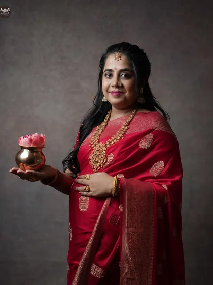 A closer portrait of the mother-to-be, focusing on her expression and the intricate details of her jewelry. This is from a studio session for a traditional baby shower.