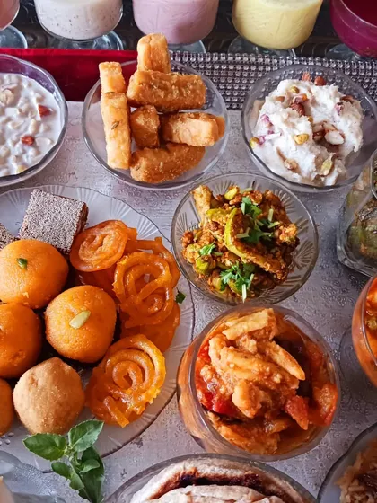 A variety of sweets and snacks from the vegan feast. This image features dairy-free shrikhand, gurpara, and other traditional treats that are central to any celebration.