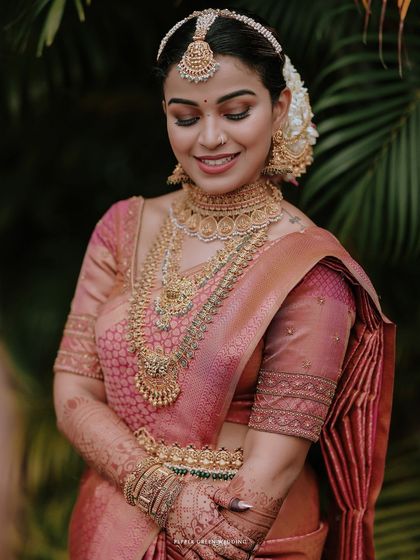 A stunning close-up of the bride, her intricate gold jewelry and serene smile captured beautifully.
