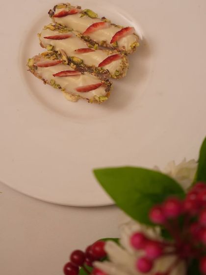 A sneak peek at our Christmas Profiteroles. These light pastries are filled with cream and topped with fresh strawberries and pistachios, available only for the festive season.