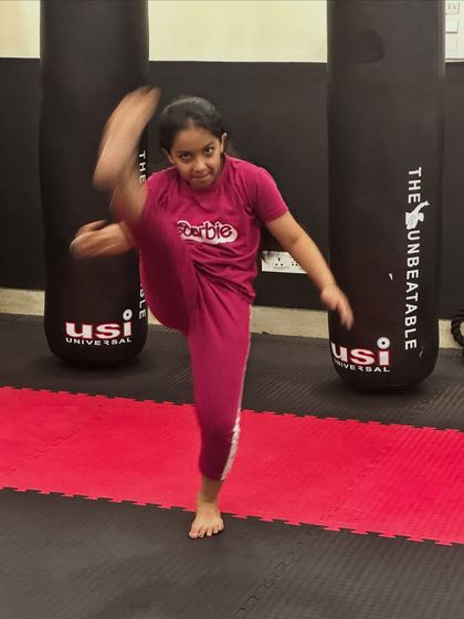 A young student demonstrates a high kick with impressive flexibility and balance. We nurture talent from a young age, focusing on proper technique and body control.