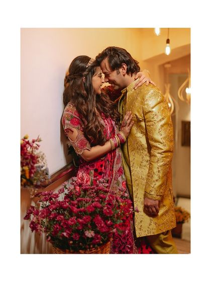 A romantic and artistic shot of the couple surrounded by flowers, capturing the beautiful decor and their intimate connection.
