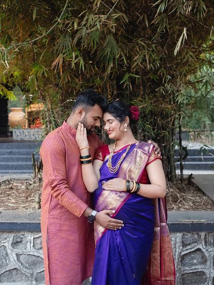 An intimate moment between the couple, framed by bamboo. Her beautiful purple saree and his traditional kurta create a look that is both elegant and deeply rooted in culture.
