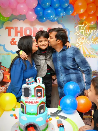 A sweet family photo of Damian with his parents and his amazing Thomas the Tank Engine cake. I've been making his cakes for years.