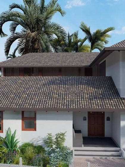 The exterior of the laterite villa in Morjim, featuring a traditional tiled roof and white walls that are characteristic of Goan architecture.