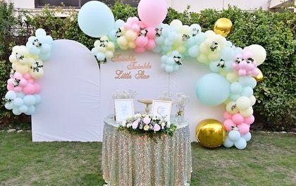 A sweet 'Twinkle Twinkle Little Star' theme with a pastel balloon arch over a white backdrop, perfect for an outdoor garden party.