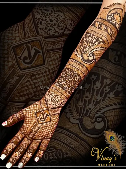 A sophisticated back-of-hand design incorporating the initials 'NJ' into the pattern. The design flows beautifully from the fingertips to the forearm.