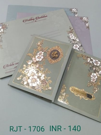 This gate-fold invitation in a soft sage green features beautiful 3D flowers with gold foil details. The Ganesha emblem adds an auspicious touch to this elegant design.