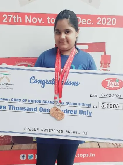 One of our young champions proudly displaying her medal and a prize of Rs. 5,100 at the Guns of Nation Grand Prix. We encourage our shooters to participate in competitions from an early age.