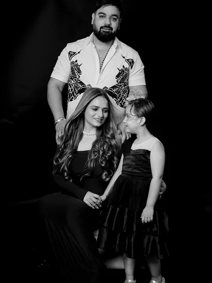 A tender black and white portrait of a mother and daughter. The simple, dark background allows the emotional connection and gentle interaction between them to shine through.