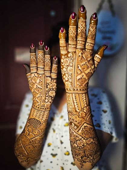 A full view of an intricate bridal design, with every inch of the hands and arms covered in beautiful patterns.