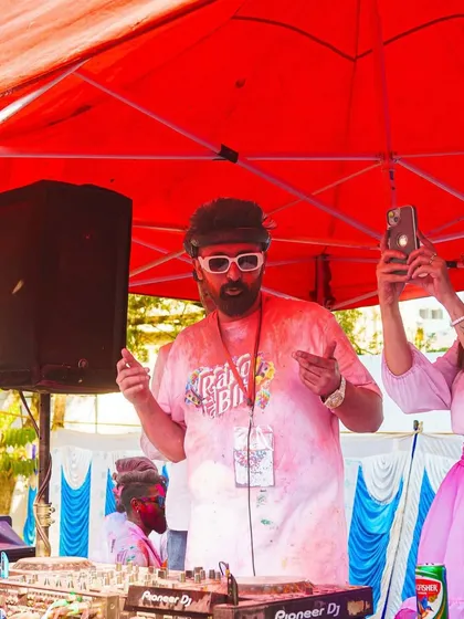 Covered in red gulal but still on the decks, spinning tunes for the Holi party. The energy is always worth it.