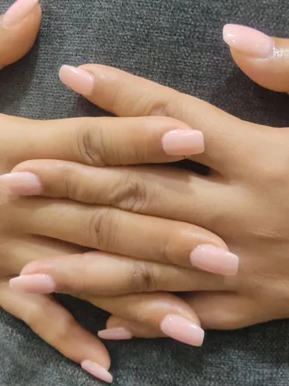 A clean and simple set of square-shaped nail extensions in a soft, natural pink shade, perfect for an elegant, everyday look.