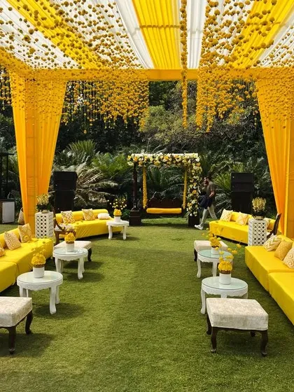 This is the classic Haldi vibe I love to create. The entire space is drenched in sunshine yellow, with marigold curtains, comfortable sofas for guests, and a decorated jhoola, making it perfect for photos and fun.