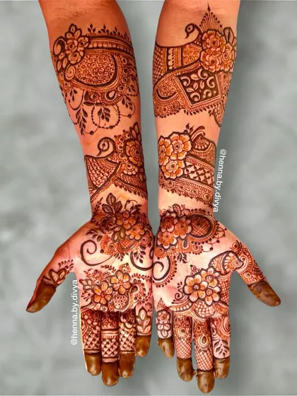 A beautiful full-sleeve bridal design with a mix of floral and traditional motifs. The palms are covered in dense flower patterns, while the arms feature peacocks and elephants.