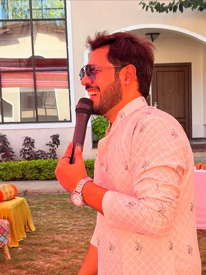 A close-up shot, mic in hand, with a genuine smile. This is me, completely in my element at a family celebration.