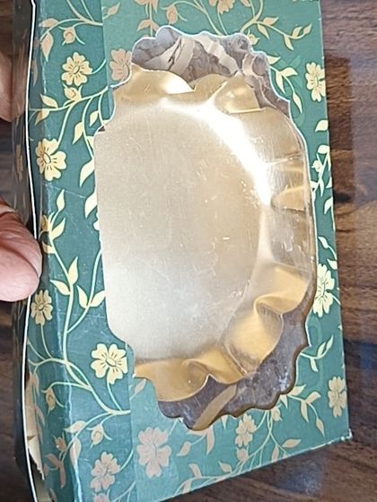 The green floral box shown with a golden urli inside, demonstrating its use for packaging items other than soaps or candles.