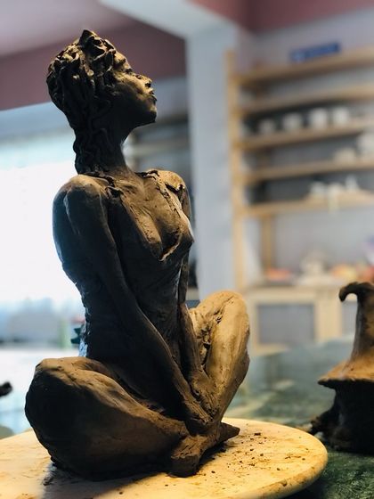 A side view of the 'Naughty Girl' sculpture, showcasing the dynamic pose and intricate details.