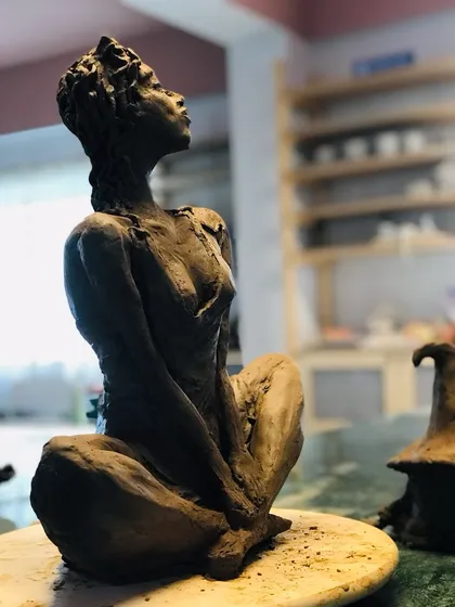 A side view of the 'Naughty Girl' sculpture, showcasing the dynamic pose and intricate details.