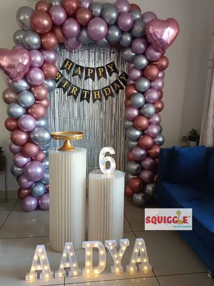 A full view of the stylish 6th birthday home decoration with a metallic balloon arch.