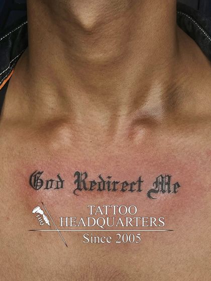 A chest tattoo with the prayer "God Redirect Me" in a bold, gothic font.