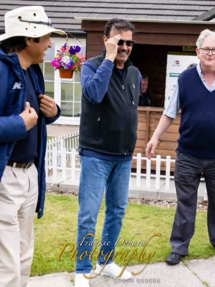 In conversation with fellow cricketers and friends during a break in play. These informal discussions are often where the most valuable lessons are shared.