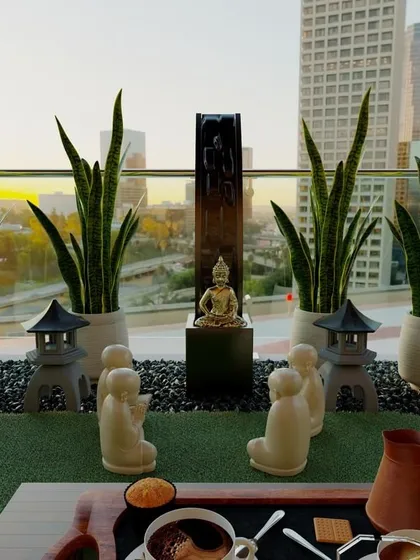 This Zen-themed balcony design brings a sense of peace high above the city. The space features low-maintenance snake plants, a calming water feature, and symbolic decor to create a perfect spot for meditation and gratitude.