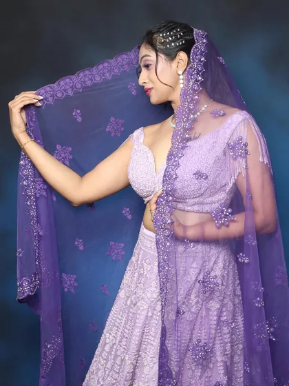 A graceful shot with the dupatta, showing the sheer fabric and the intricate embroidery of the outfit.