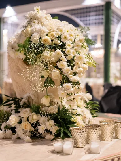 A close-up of a lush, all-white floral arrangement, showcasing the beauty and texture of the flowers.