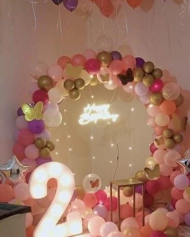 A wider view of the butterfly-themed birthday, including a large light-up number '2'.