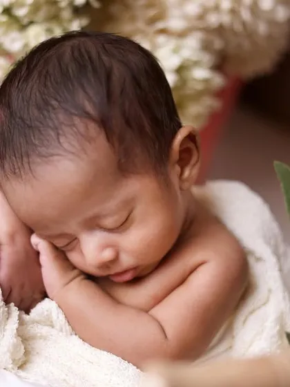 A close-up portrait of a sleeping newborn, focusing on their delicate features and peaceful expression. These simple shots are often the most powerful.