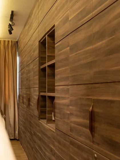Another view of the full-wall cabinet, which also serves as the headboard for the bed. This dual-purpose design is a great space-saving solution for modern apartments, providing ample storage without sacrificing style.
