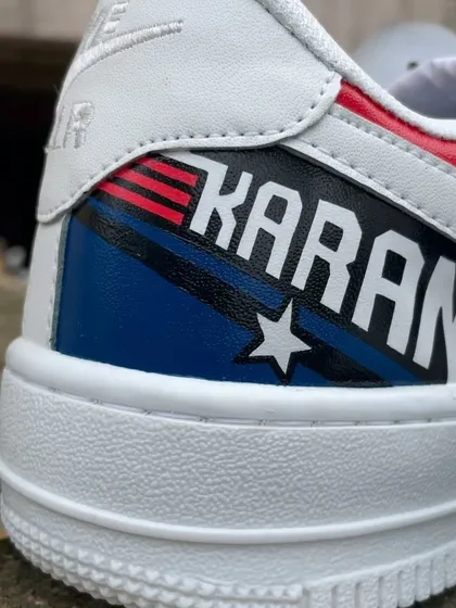 A detailed close-up of the heel, where we painted the client's name "KARAN" in the iconic Top Gun font with star and stripe details.