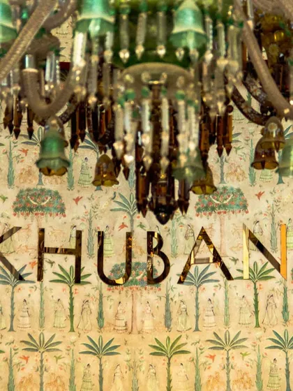 The glamour of Khubani is suspended in the air. This stunning green chandelier, set against our signature artistic wallpaper, is a centerpiece of our decor, blending luxury and timeless charm to create a truly radiant affair.