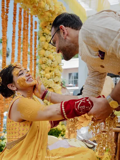 A sweet, candid moment between the bride and groom during their Haldi ceremony, filled with smiles and affection.