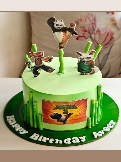 An action-packed Kung Fu Panda cake with edible character toppers of Po, Tigress, and Master Shifu, set against a bamboo backdrop.