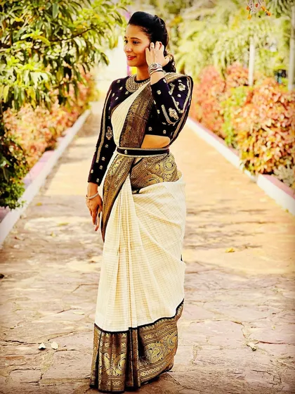 A full view of our client wearing a custom long-sleeve blouse with her traditional Kanjeevaram saree, complete with an embroidered belt.