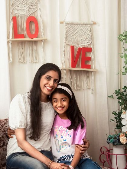 A sweet embrace between a mother and daughter. This studio portrait, with its lovely boho decor, is a beautiful testament to their bond.