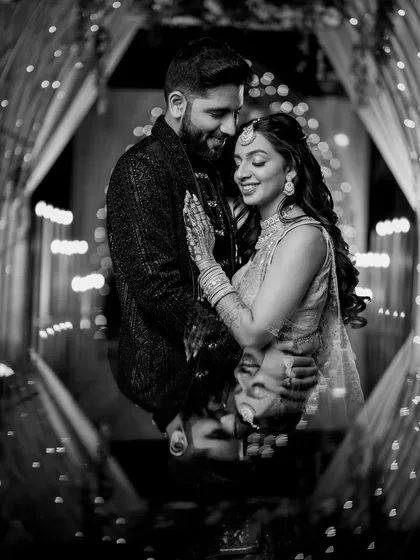 A timeless black and white portrait from Zaee and Kartik's Sangeet, framed by the beautiful, glowing lights of the decor.