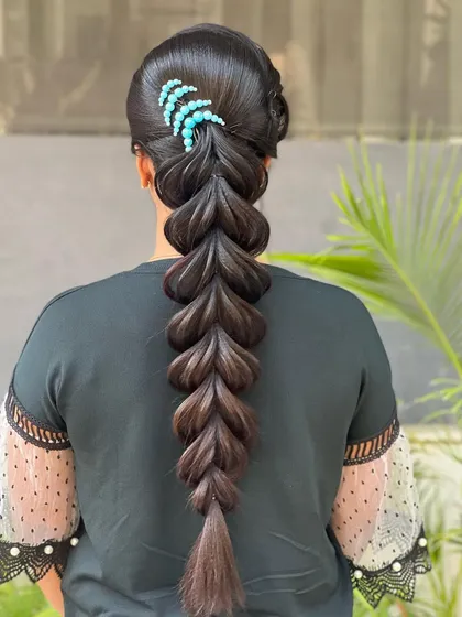 The final look of the pulled-apart braid, accented with a simple blue hair clip.