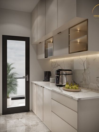 Another view of the modern parallel kitchen, this time showing the under-cabinet lighting that illuminates the workspace. The combination of white marble and light-colored laminates makes the space feel bright and spacious.