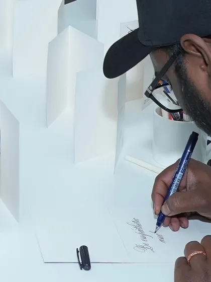 Learn the elegant art of calligraphy and add a personal, handmade touch to cards, letters, and artwork. Our instructor is demonstrating a brush lettering technique, one of several styles we explore in our classes. It's a timeless skill that brings beauty to the written word.