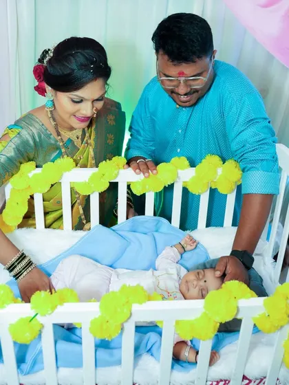 The naming ceremony is such a special tradition. Here, new parents look lovingly at their baby resting in a beautifully decorated cradle.