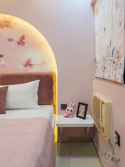 A closer look at the details in the pink butterfly room. The floating nightstand is a space-saver, and the themed decor pieces like the bunny and framed picture make it feel personal.