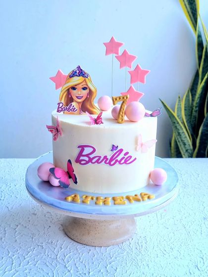 A full view of the simple Barbie cake on its stand.