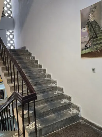 A painting of a staircase hangs in the gallery during our students' visit to the College of Art exhibition.