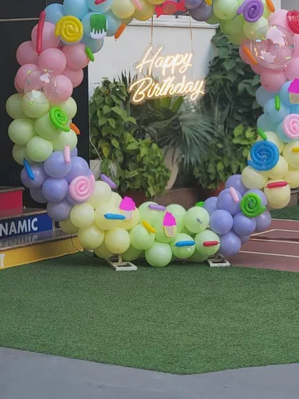 A unique 'Happy Birthday' photo spot with a circular balloon arrangement decorated with candy and ice cream shapes.