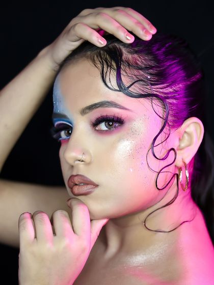 A close-up portrait that highlights the glitter and pearl details of the makeup.